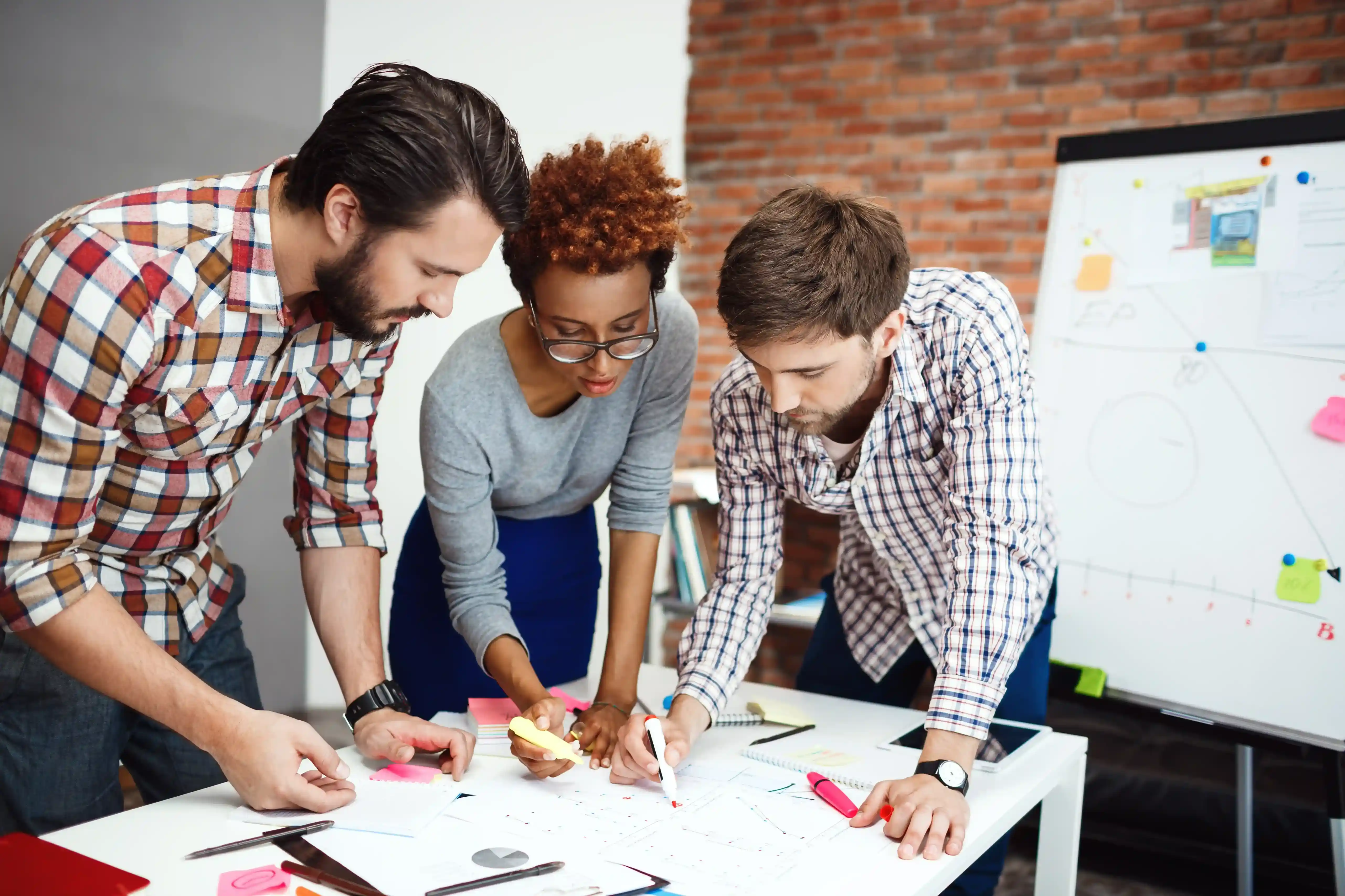 A design team sketching layouts together at a whiteboard table