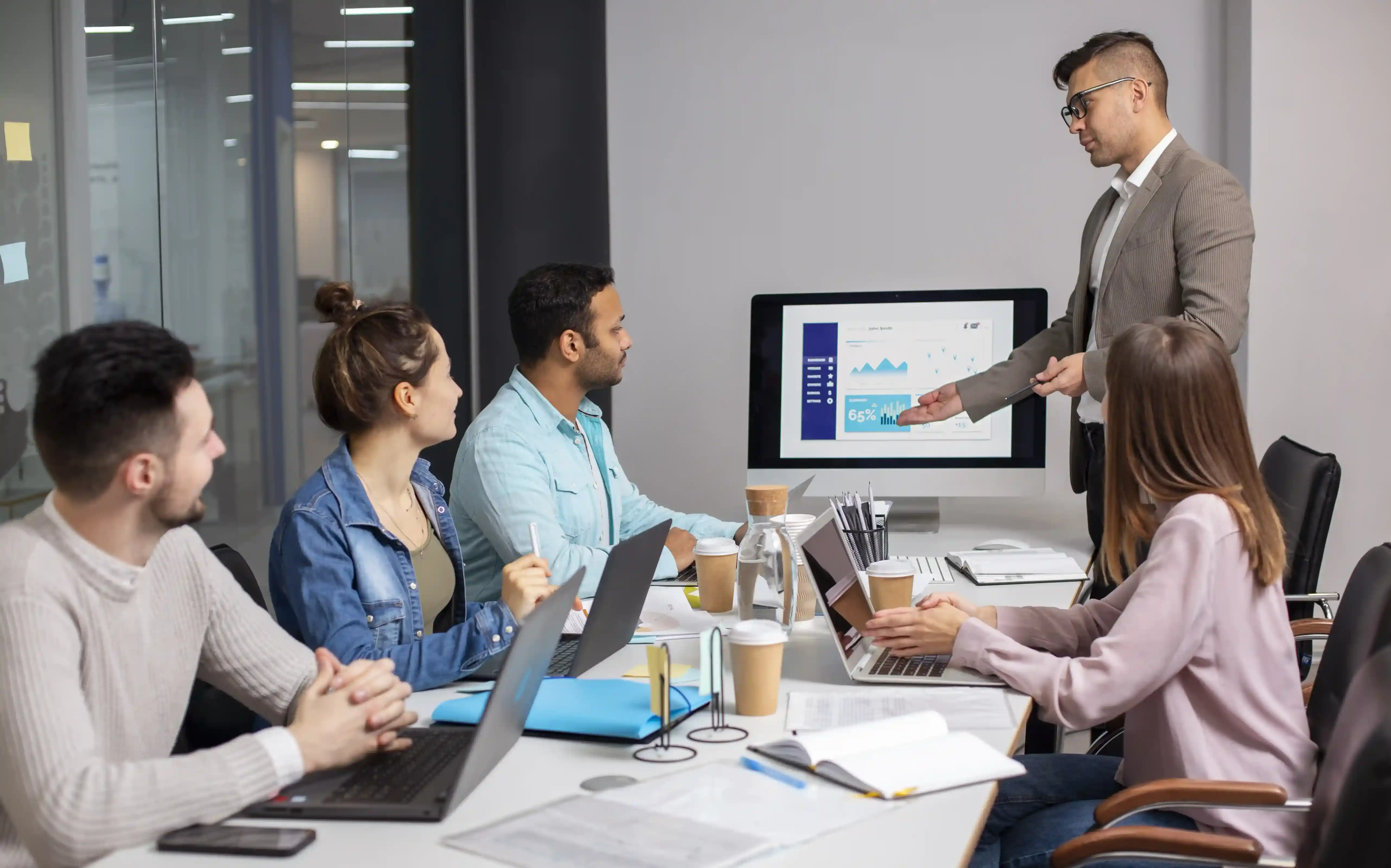 A marketing team reviewing campaign results on a screen in a meeting room